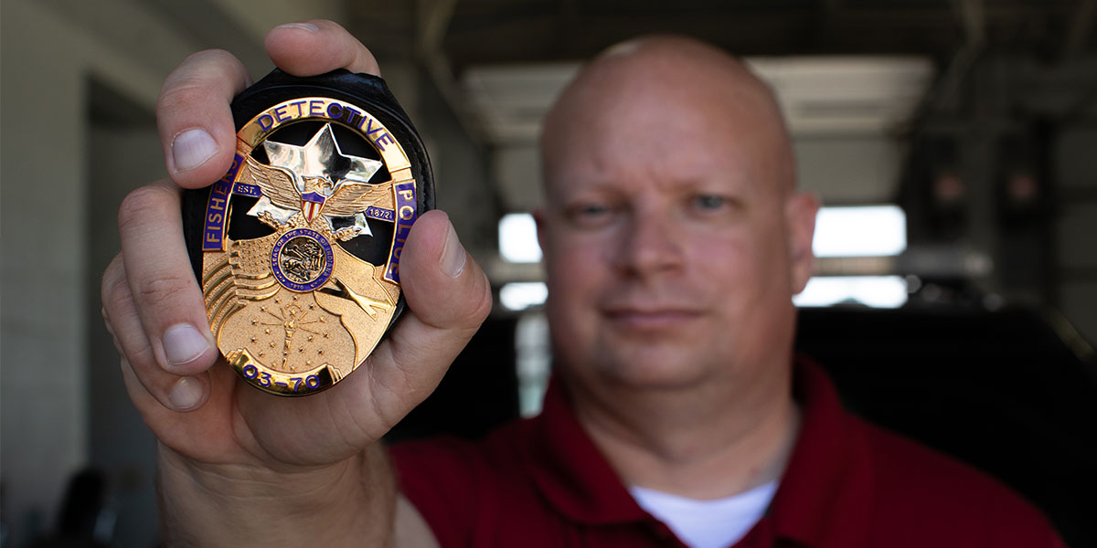 Fishers Police Badge being held