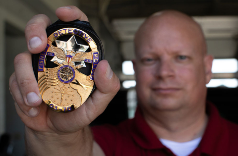 Fishers Police Badge being held